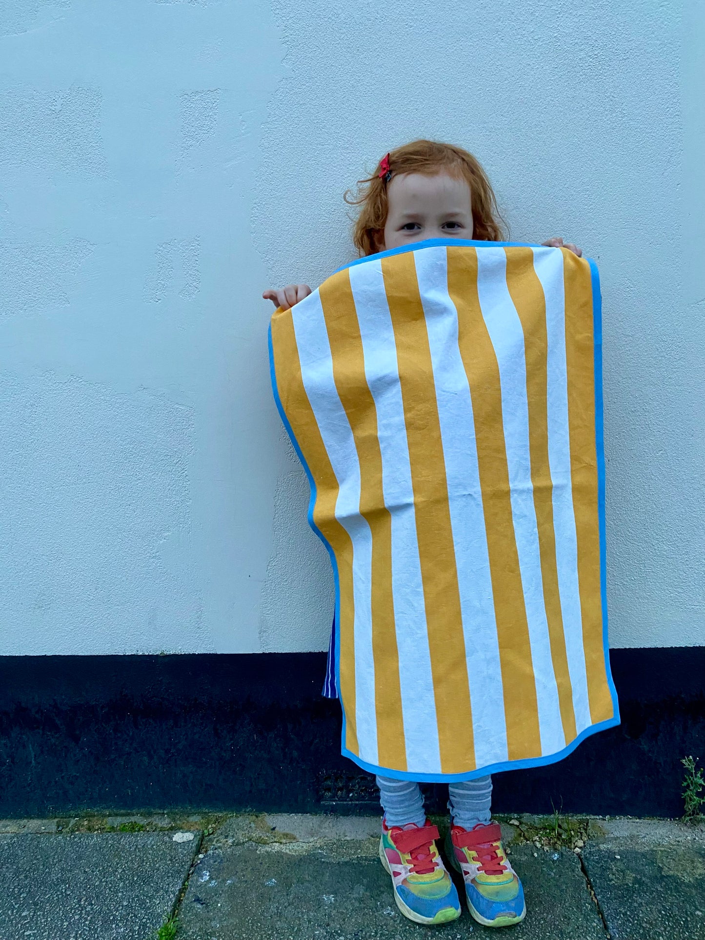 yellow striped tea towel with blue edging
